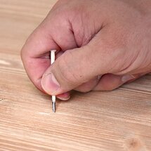 Löcher in das Holz stechen