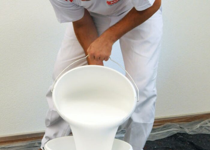 Danach schütten Sie die nötige Farbe in einen leeren Farbeimer.