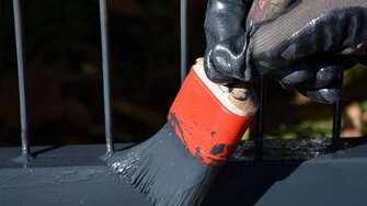 Nach 24 Stunden Trocknungszeit gönnen Sie Ihrem Tor den zweiten Anstrich: Erst mit dem Pinsel und dann wieder mit dem Roller.