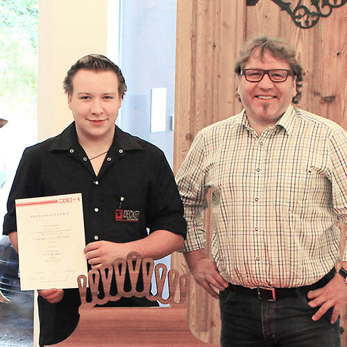 Florian Decker (re.) präsentiert stolz seine Auszeichnung, den "Tischlerpreis 2017".
